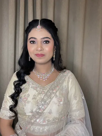 An elegant engagement look for this bride in a white lehenga. The makeup is soft and romantic.
