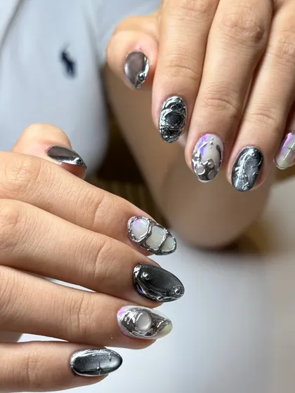 This photo shows the 3D chrome nails in a different light, highlighting the pearlescent base and the way the metallic elements catch the light.