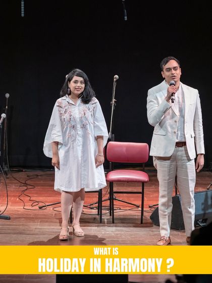 Our founders, Shivani and Vivek, on stage introducing 'Holiday in Harmony'. They are the visionaries behind our ambitious and heartwarming musical productions.