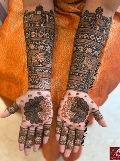 A unique take on bridal mehendi with fully covered arms and minimalist palms. The arms feature traditional elephants and peacocks, while the palms have a simple, elegant peacock design.