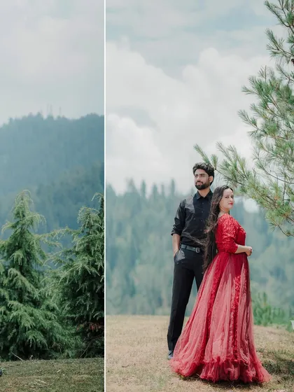 A couple stands together in a clearing, framed by tall pine trees and a mountain landscape. The contrast between the red dress and the natural greenery makes for a striking portrait.