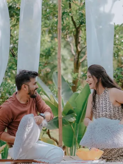 A playful pillow fight during a picnic-style pre-wedding shoot. This fun and energetic activity brings out genuine laughter and creates dynamic, memorable photos that show the couple's lighthearted connection.
