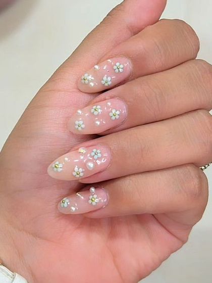 A sweet and subtle design with tiny, hand-painted daisies and small pearls scattered across sheer, natural-looking extensions.