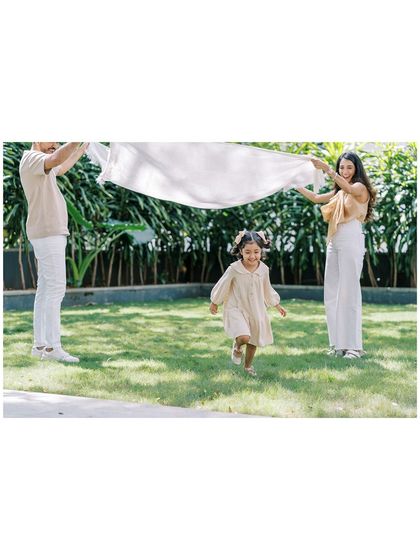 A family playing with a sheet in the park. A fun and creative way to get action shots.