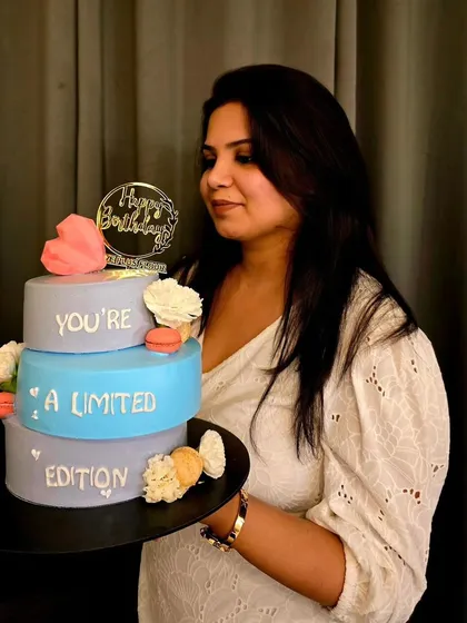 You are a limited edition, and your cake should be too. I'm holding one of my favorite tiered pastel cakes, adorned with delicate macarons and a heartfelt message, perfect for a truly personal celebration.