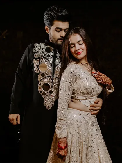 A romantic portrait of a couple on their Sangeet night, the groom's mirror-work kurta adding a touch of sparkle.