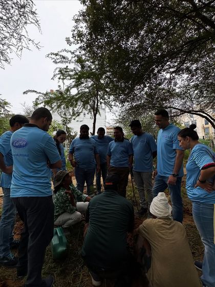 The Carrier India team gathers for a demonstration on planting native species, learning about the fragile ecosystem where rocky land meets porous bhood land.