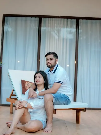 A relaxed and intimate moment at a modern resort-style location. This shot captures the couple enjoying a quiet celebration with champagne, showcasing a casual yet sophisticated pre-wedding vibe.
