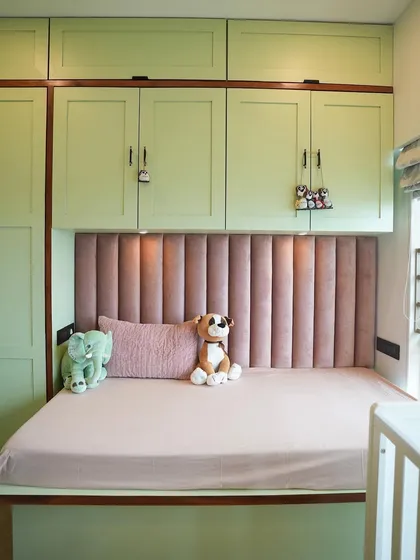 The daybed is nestled into a nook with built-in overhead storage, making it a cozy spot for reading and a practical solution for a growing child.