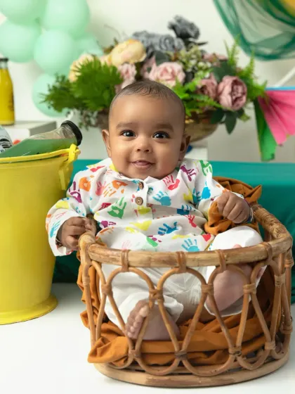 A sweet and smiling baby ready to celebrate his first Holi in a colorful and safe studio environment.