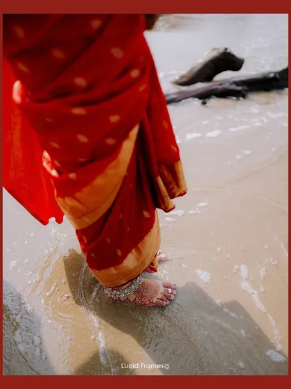 A beautiful detail shot of the bride's feet and anklet as the ocean waves wash over the sand.