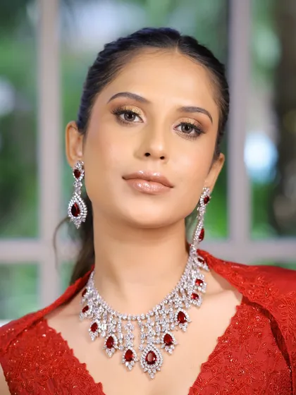 A full-face view of this glamorous red-dress look. The glossy nude lips and defined bronze eyes create a powerful yet sophisticated statement, ideal for any evening celebration.