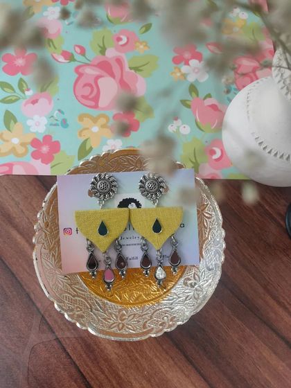 These yellow fabric earrings feature an oxidized silver stud and dangling multi-colored beads. They are lightweight and perfect for long nights of dancing during Navratri.