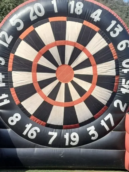 This giant inflatable football dart game is a unique and eye-catching activity. Players kick velcro footballs at the huge dartboard, making it great for sports-themed parties and corporate team building.