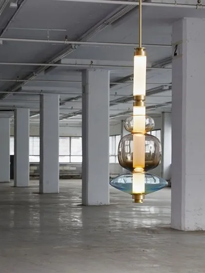 A single, large-scale Luna Kaleido pendant hangs in an industrial space, demonstrating its ability to hold its own as a singular statement piece even in a vast, open environment.