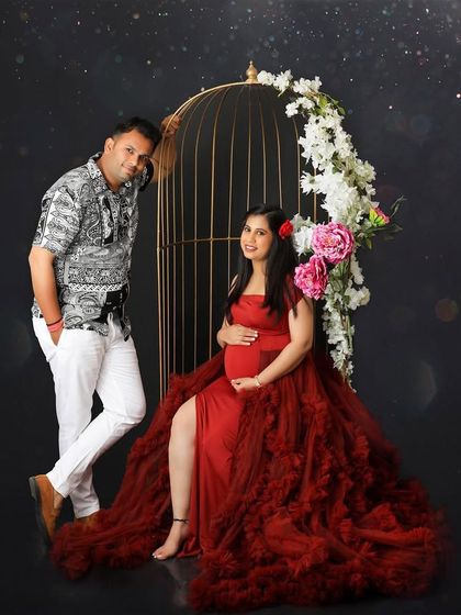 A simple and sweet portrait of a couple ready for their next chapter. The mom-to-be looks radiant in red, seated next to her partner.