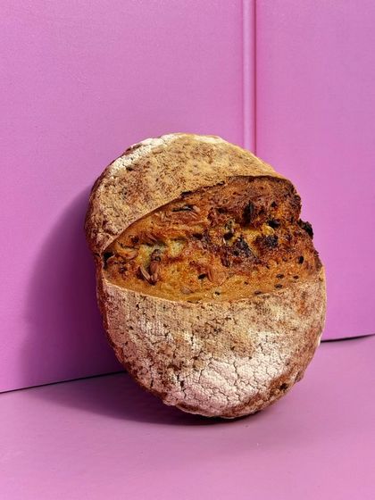 A beautiful shot of our seeded sourdough boule. It has a crackly crust, a tangy crumb, and is loaded with a mix of delicious seeds.