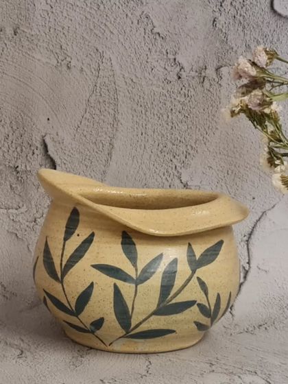 Another view of the hand-painted flower vase. Its unique, altered shape makes it a beautiful decorative object even without flowers.