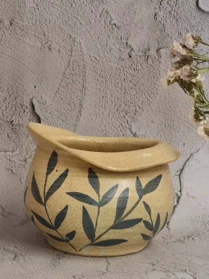 Another view of the hand-painted flower vase. Its unique, altered shape makes it a beautiful decorative object even without flowers.