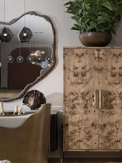 The Luna Kaleido series is reflected in an organic-shaped mirror, showcasing the beautiful textures of the shaped glass beads. This image, taken at the India Design Fair, highlights the collection's artistic appeal.