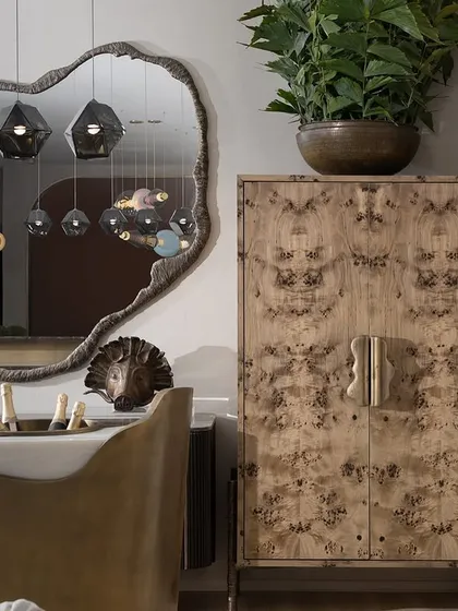 A reflection of a different lighting installation in a mirror, framed by the elegant furniture and a striking burl wood cabinet. This image shows how I curate entire spaces, not just lighting.