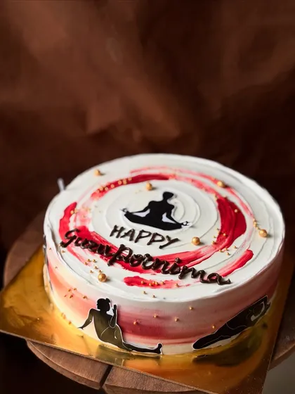 Another angle of the Guru Purnima cake, showing the details of the yoga poses around the base.