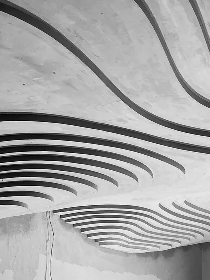 A work-in-progress shot of a sculpted ceiling, captured in black and white. Even in its raw state, the power of the undulating, organic form is clear. This is where we begin to see the poetry of the structure emerge.