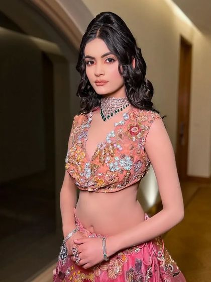 A front-facing portrait showcasing the intricate floral embroidery on the blouse.