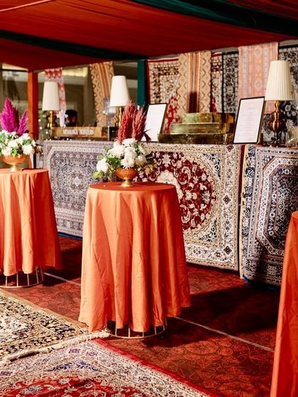 A unique bar setup with a facade made of various patterned rugs, fully integrating the bar into the overall Moroccan bazaar theme.