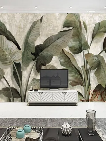 This wallpaper features large, muted green banana leaves on a textured background, creating a sophisticated and calming accent wall behind a TV unit.