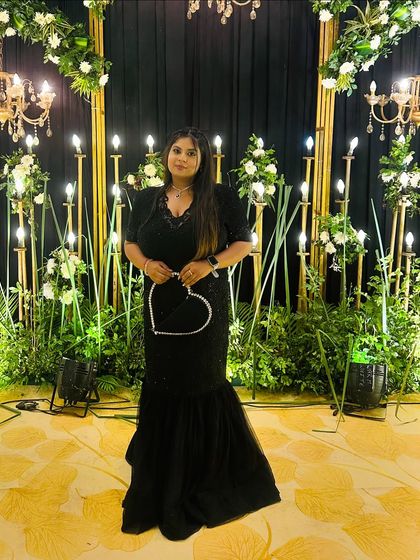 The full look of the black plus-size fish-cut gown against a beautiful floral backdrop. It’s a perfect outfit for a glamorous evening.