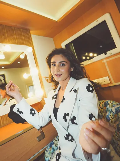 A behind-the-scenes moment from a shoot with Dhvani Bhanushali. This candid shot in a floral pantsuit from Lovechoje shows the fun and relaxed energy on set.