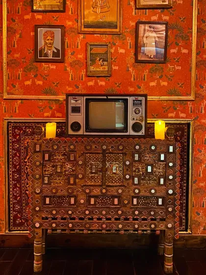 A blend of vintage and classic. An old television set sits atop an intricately carved chest, creating a nostalgic corner that speaks to the timelessness of our decor.