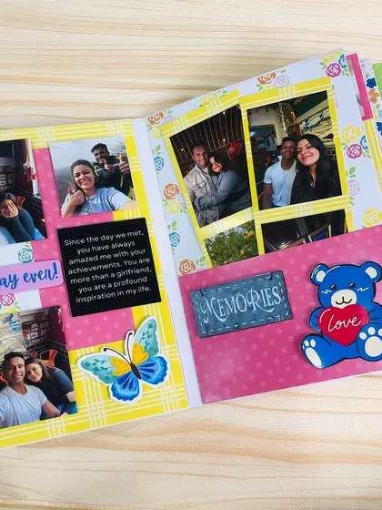 An inside page of the scrapbook, showing a collage of photos, a personal message, and cute embellishments like a teddy bear and butterfly.