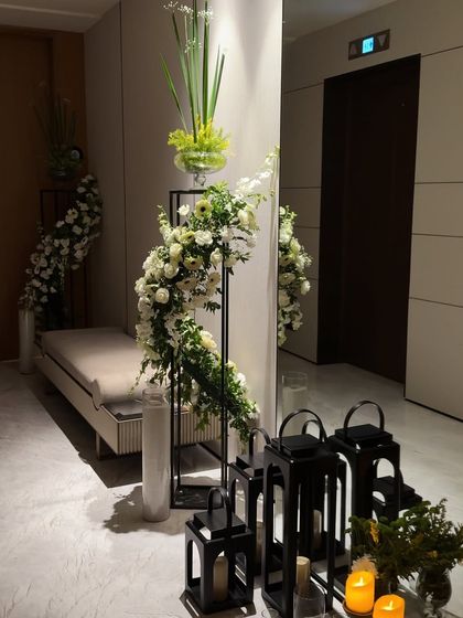 A different perspective of the modern floral and lantern entryway decor, showcasing the clean lines and elegant contrast between the black fixtures and white flowers.