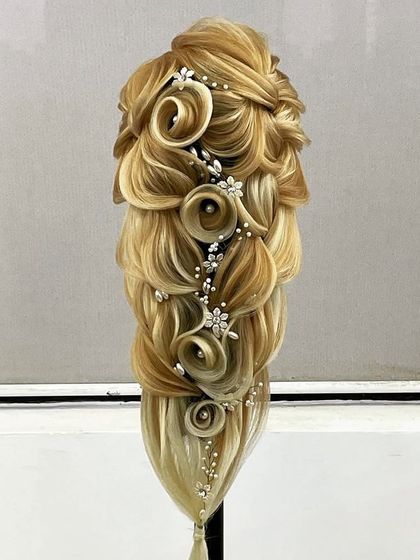 An incredibly detailed and artistic hairstyle, combining multiple techniques like braiding, loops, and floral shaping. This represents the pinnacle of skills taught in our advanced program.
