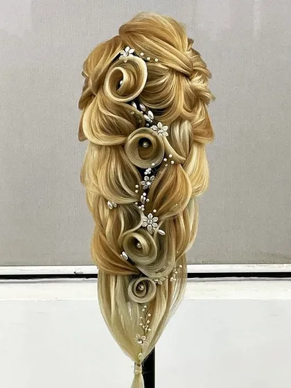 An incredibly detailed and artistic hairstyle, combining multiple techniques like braiding, loops, and floral shaping. This represents the pinnacle of skills taught in our advanced program.