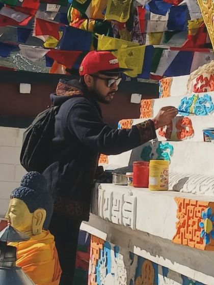 A close-up of me painting the intricate patterns on the Stupa. The attention to detail and the meaning behind each element was a profound lesson in artistry.