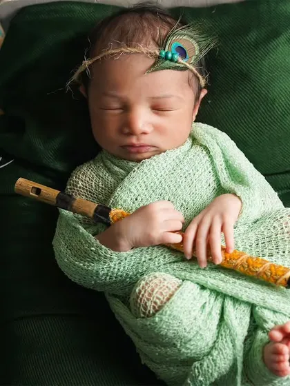 A tiny Krishna holding his flute. We use safe wrapping techniques to keep your newborn snug and secure, allowing us to capture these precious themed portraits.