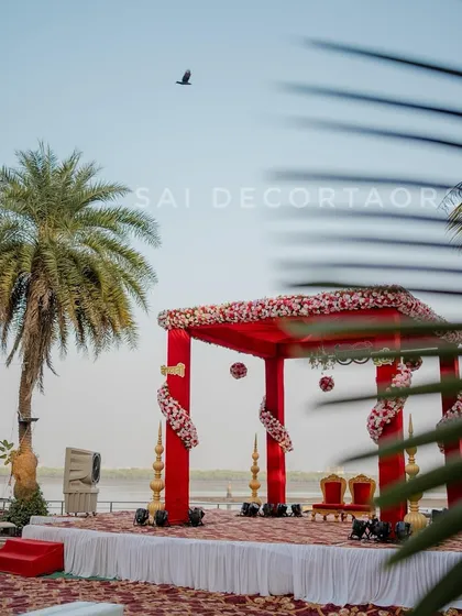 A daytime view of the red wedding mandap I set up by the water. This location in Navi Mumbai is great for outdoor weddings, and my decor is built to look good in any light.