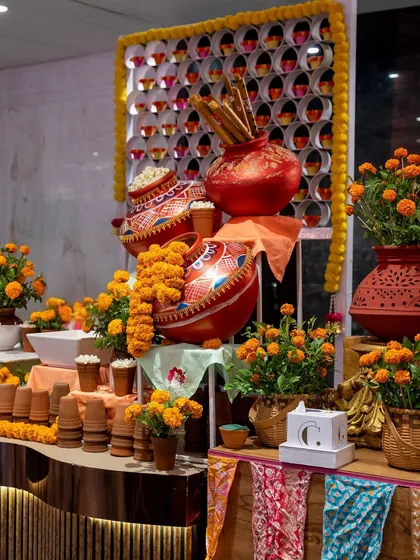 A festive counter decorated with marigolds and earthen pots. This setup, designed for a traditional celebration, creates a warm and inviting atmosphere for guests to enjoy our food.