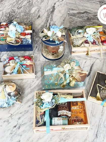 An assortment of our snack and treat hampers, showcasing a variety of packaging styles from boxes to baskets, all in a coordinated blue and white theme.