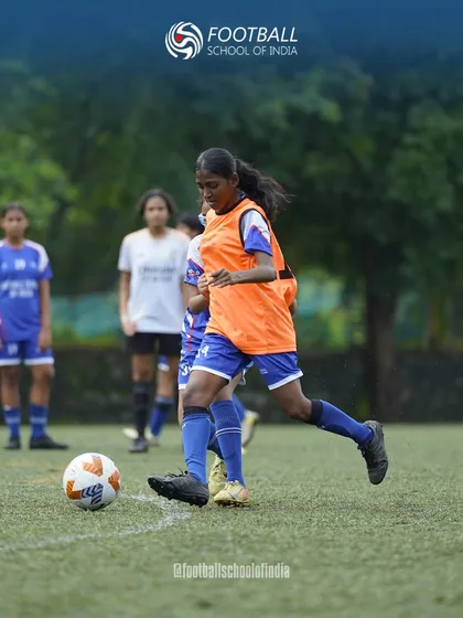 A player in an orange bib practices her striking technique. Our training sessions include position-specific drills to develop every aspect of a player's game.