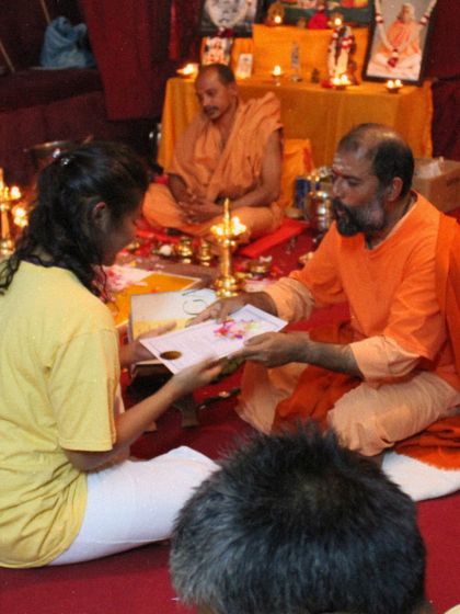 A throwback to a graduation ceremony, where a student receives her certificate in a room filled with reverence and tradition.