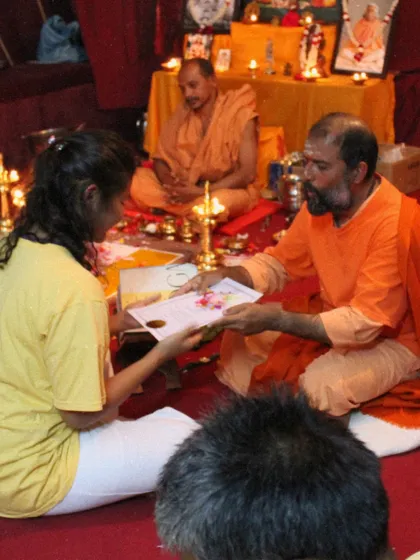 A throwback to a graduation ceremony, where a student receives her certificate in a room filled with reverence and tradition.