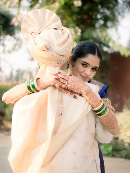 A warm hug from the groom, with the bride looking over his shoulder with a serene smile.