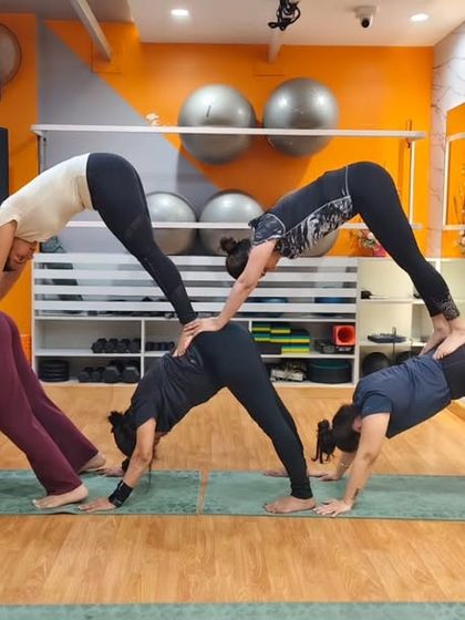 Another look at our partner downward dog pyramid. It's a fantastic way to deepen the stretch in the shoulders and hamstrings with the help of your friends.
