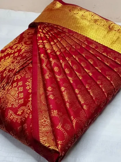 A classic red and gold bridal silk saree, pleated to perfection.