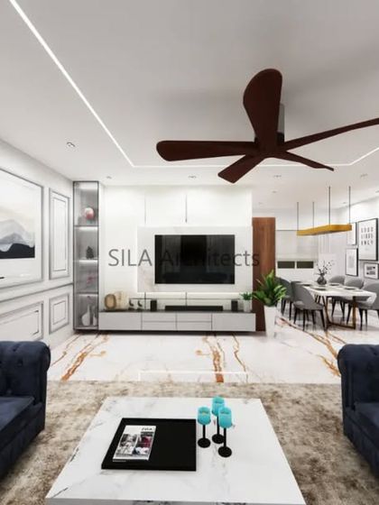 A render of a spacious living room with deep blue chesterfield sofas and a clean, minimalist TV unit. This visualization helps in selecting furniture and color schemes that reflect the client's style.