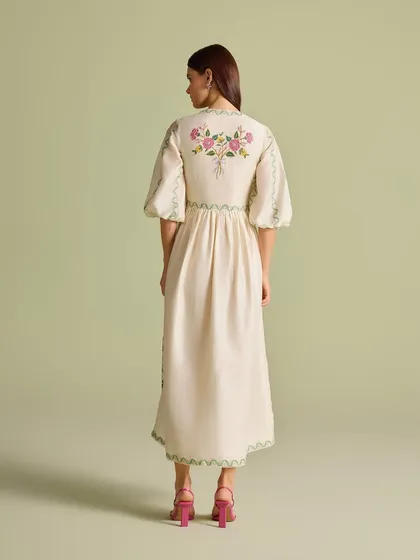 The back view of the dress, highlighting the delicate bouquet of flowers embroidered between the shoulders.